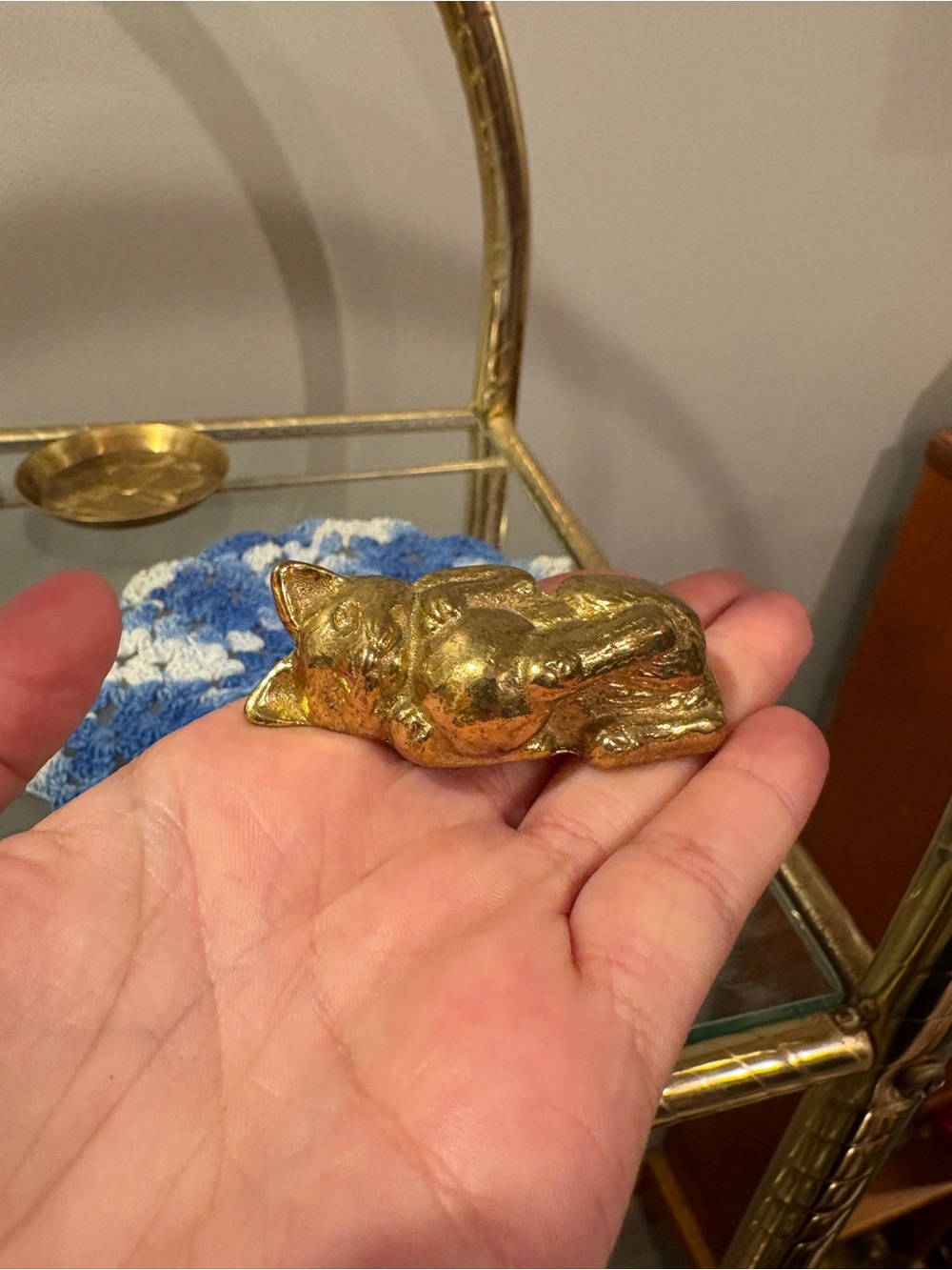 Brass cat playing with ball
